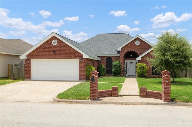 1614 Gabriels Lndg, Harlingen, TX 78550 - traditional-style house with a front lawn, a garage, driveway, and brick siding