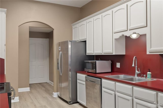 1614 Gabriels Lndg, Harlingen, TX 78550 - kitchen featuring appliances with stainless steel finishes, a sink, light wood-type flooring, and white cabinets
