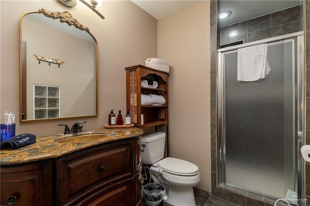 full bath with a stall shower, vanity, and toilet