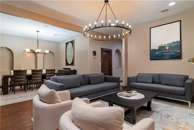 living room with visible vents, arched walkways, wood finished floors, a notable chandelier, and recessed lighting