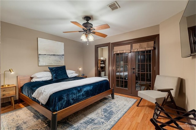 bedroom featuring access to outside, visible vents, ceiling fan, and wood finished floors