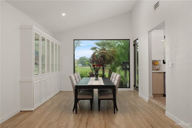 807 Cimarron Dr, Mission, TX 78572 - dining space with light wood-style flooring, baseboards, recessed lighting, and high vaulted ceiling
