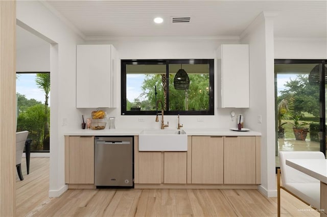807 Cimarron Dr, Mission, TX 78572 - kitchen featuring stainless steel dishwasher, a sink, light wood-style floors, light countertops, and crown molding