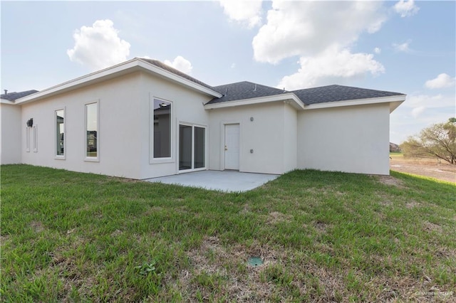 rear view of property featuring a yard and a patio area