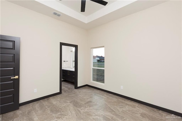 unfurnished room with a raised ceiling and ceiling fan