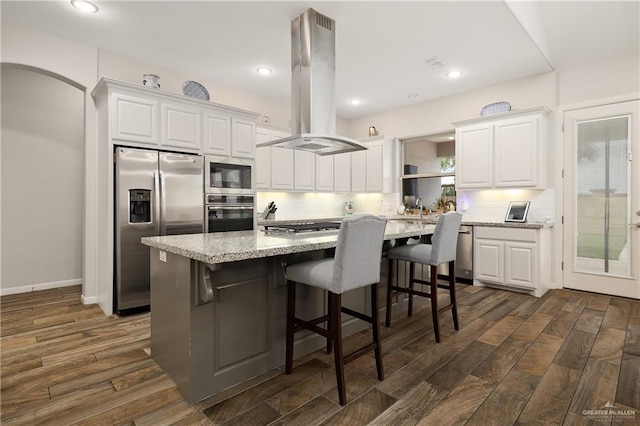 kitchen featuring white cabinets, island exhaust hood, and stainless steel appliances