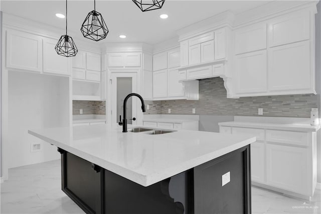 kitchen featuring sink, white cabinets, and a kitchen island with sink