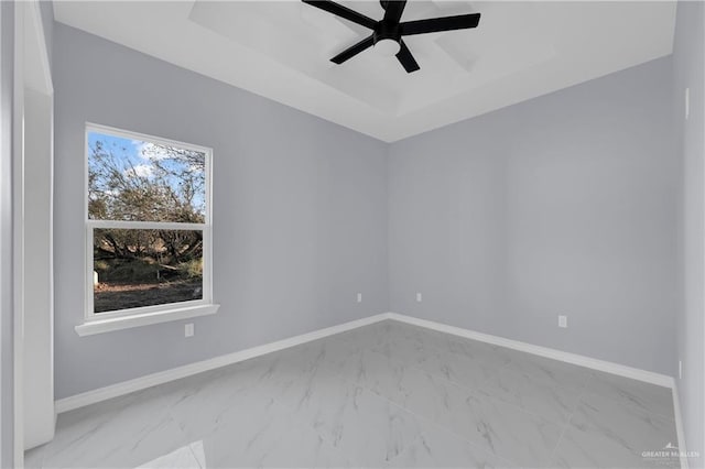 unfurnished room featuring ceiling fan, plenty of natural light, and a raised ceiling