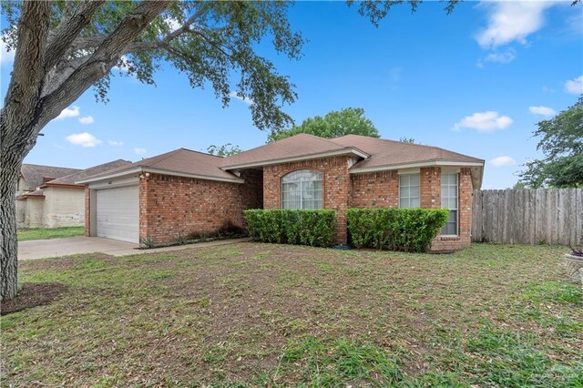 ranch-style house with driveway, a front yard, an attached garage, fence, and brick siding