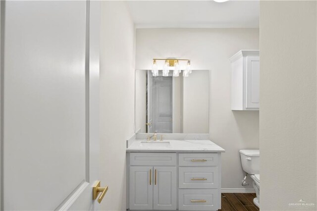 3404 Yellowhammer Ave, Mcallen, TX 78504 - half bath featuring toilet, vanity, wood finished floors, and baseboards