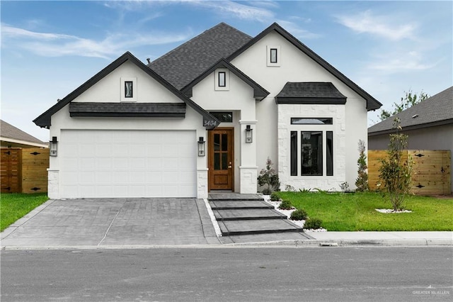 3404 Yellowhammer Ave, Mcallen, TX 78504 - view of front of property with a garage, driveway, stucco siding, a shingled roof, and stone siding