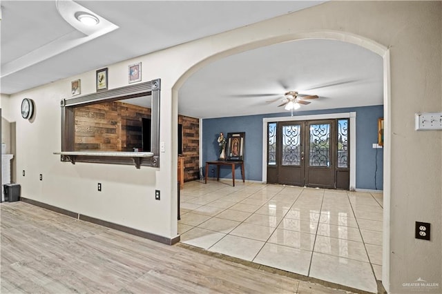 foyer entrance with light tile patterned floors, french doors, and ceiling fan