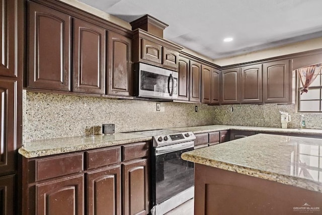 kitchen with decorative backsplash, light stone counters, dark brown cabinetry, and stainless steel appliances