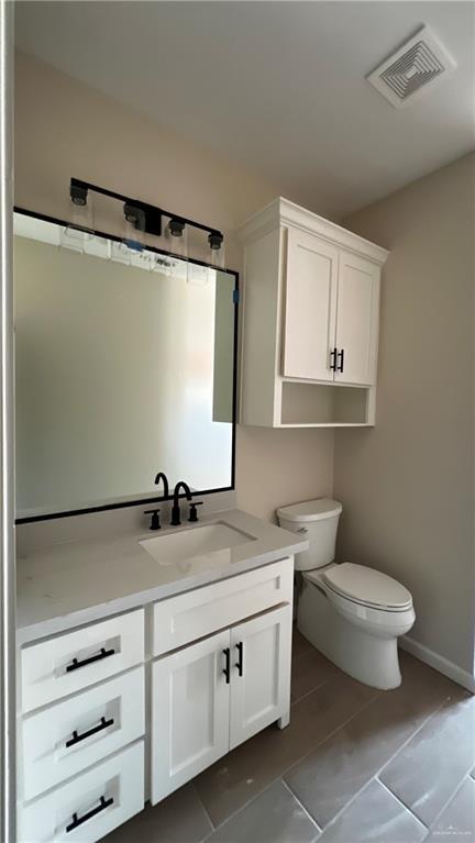 bathroom with tile patterned floors, vanity, and toilet