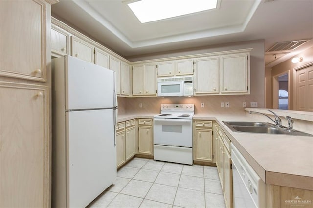 kitchen featuring sink, kitchen peninsula, white appliances, a tray ceiling, and light tile patterned floors