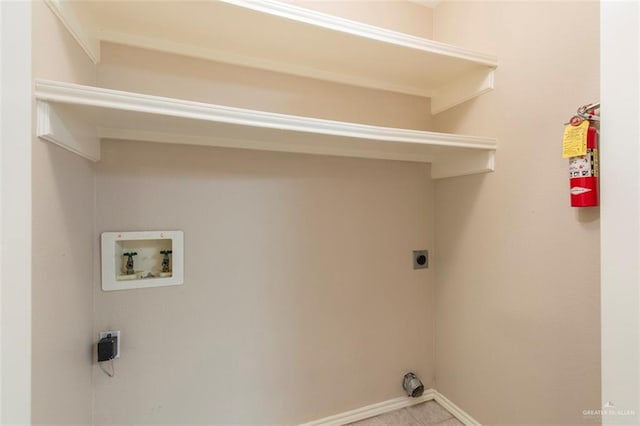 laundry area with hookup for an electric dryer, light tile patterned floors, and washer hookup