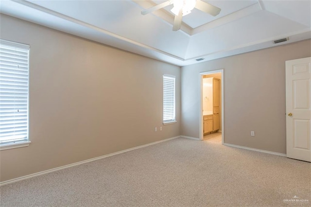 carpeted empty room with a tray ceiling and ceiling fan