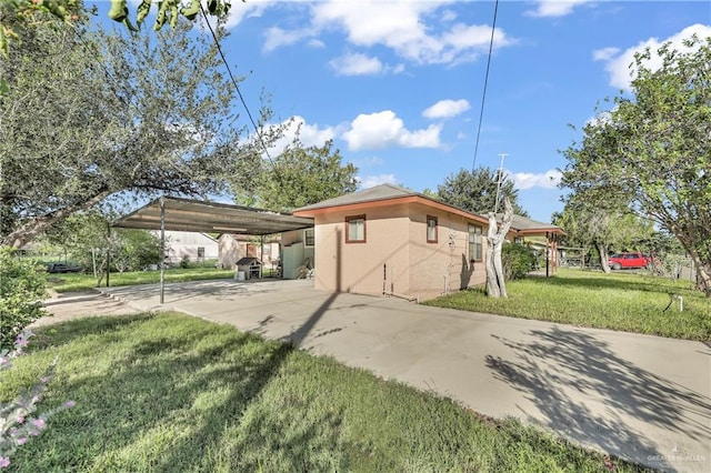 view of home's exterior with a carport and a yard