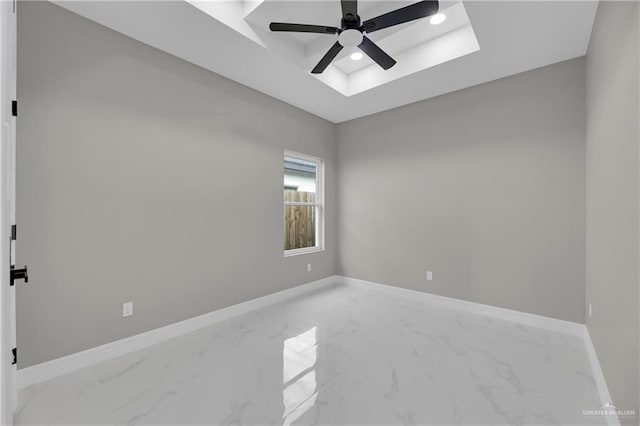 spare room with ceiling fan and a tray ceiling