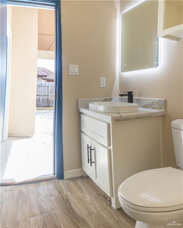 bathroom with hardwood / wood-style floors, vanity, and toilet