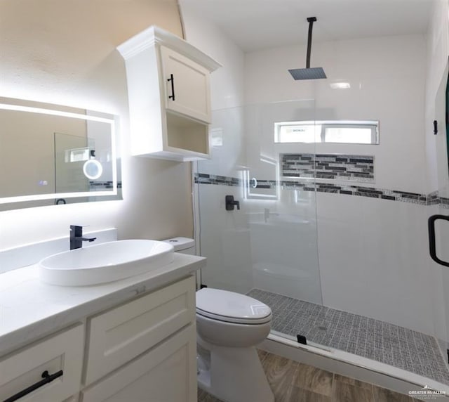 bathroom with hardwood / wood-style flooring, toilet, an enclosed shower, and vanity