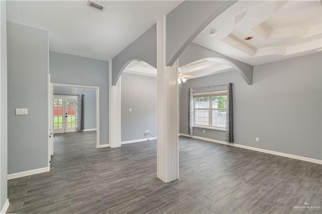 1608 Merlin Dr, Mission, TX 78572 - spare room with arched walkways, dark wood-type flooring, baseboards, a ceiling fan, and a tray ceiling