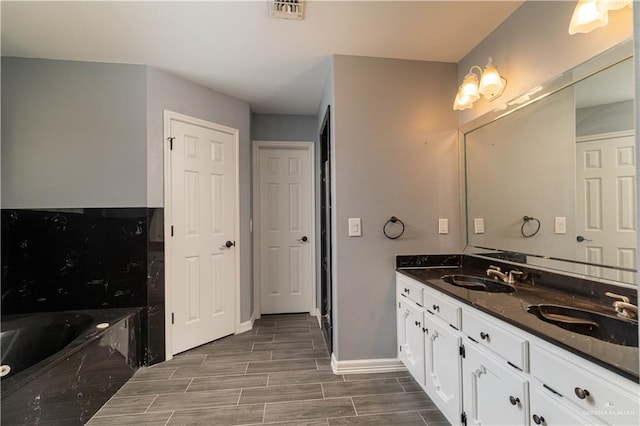 1608 Merlin Dr, Mission, TX 78572 - full bathroom featuring a bath, double vanity, baseboards, and wood tiled floors