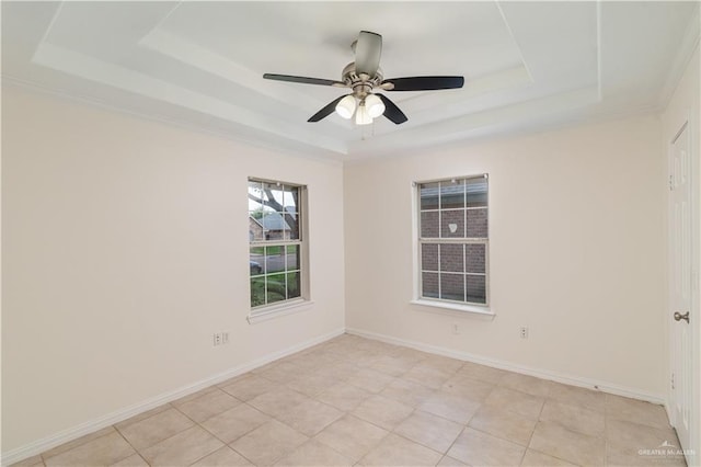 empty room featuring ceiling fan, light tile patterned floors, and a tray ceiling