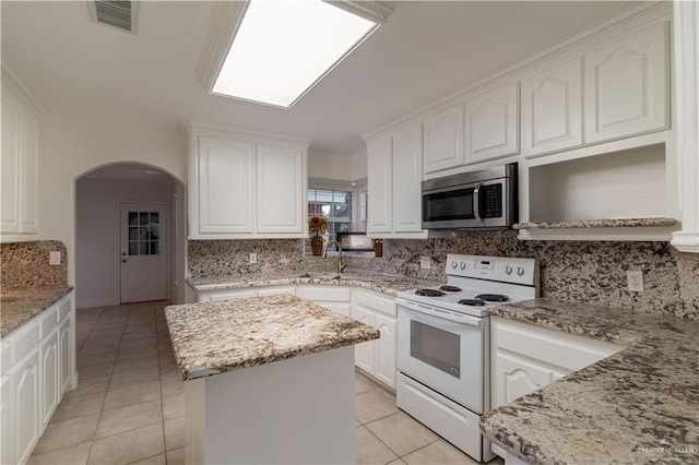 kitchen with white range with electric cooktop, light stone countertops, and a center island