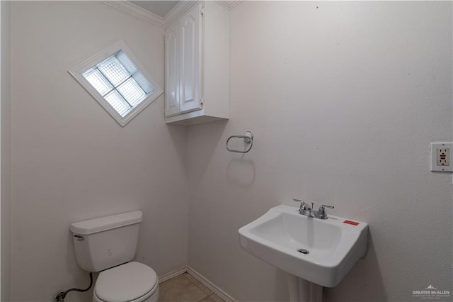 bathroom featuring tile patterned flooring, toilet, crown molding, and sink