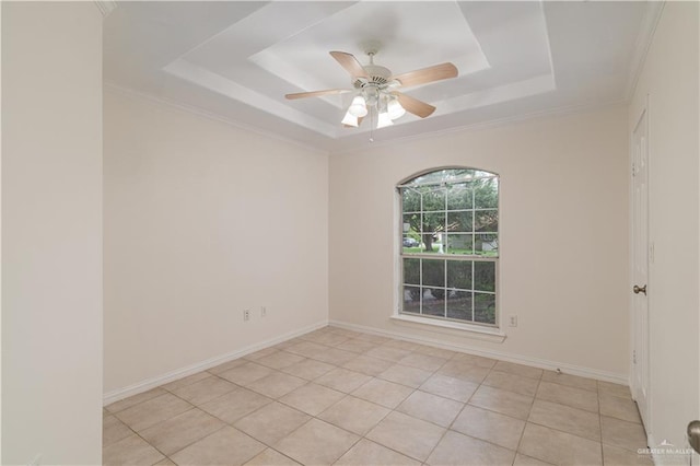 tiled empty room featuring ceiling fan, a raised ceiling, and crown molding