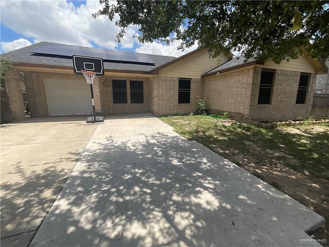 3020 Nickel Ave, Mission, TX 78574 - single story home featuring brick siding, roof mounted solar panels, an attached garage, driveway, and roof with shingles