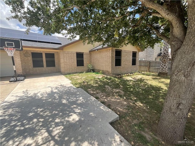 3020 Nickel Ave, Mission, TX 78574 - back of property with brick siding, solar panels, fence, driveway, and a shingled roof