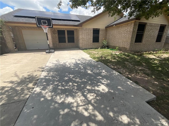 3020 Nickel Ave, Mission, TX 78574 - ranch-style house featuring solar panels, brick siding, concrete driveway, a garage, and roof with shingles