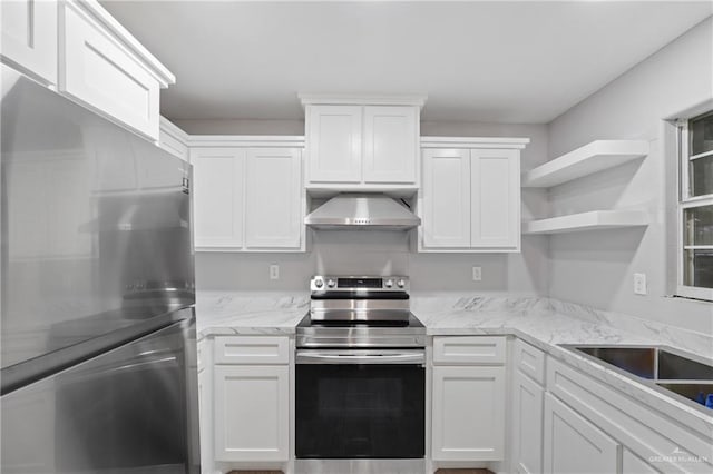 kitchen with white cabinets, wall chimney range hood, open shelves, and appliances with stainless steel finishes