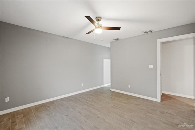 spare room featuring baseboards, ceiling fan, and visible vents