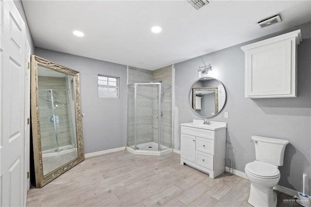 full bathroom featuring visible vents, baseboards, wood finished floors, vanity, and a stall shower
