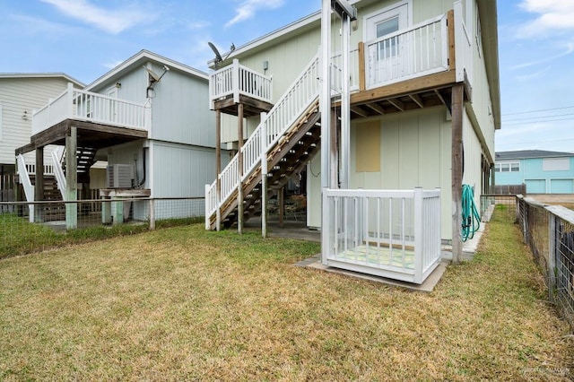 back of property with a deck and a lawn