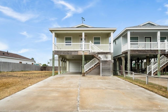 coastal inspired home with a carport, a porch, and a garage