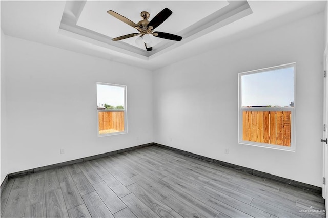 2820 Linva Ave, Mcallen, TX 78541 - unfurnished room with wood finished floors, ceiling fan, a tray ceiling, and baseboards