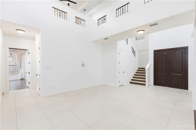 2502 Elbrus Ave, Edinburg, TX 78539 - spare room with stairway, a ceiling fan, a high ceiling, and baseboards