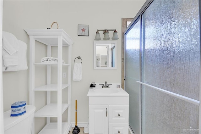 bathroom featuring vanity, an enclosed shower, and toilet