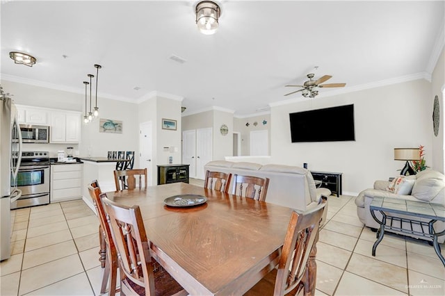 tiled dining room featuring ceiling fan and ornamental molding