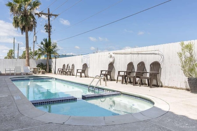 view of pool featuring an in ground hot tub and a patio