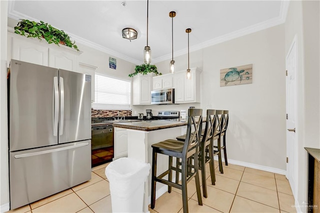 kitchen featuring appliances with stainless steel finishes, decorative light fixtures, white cabinetry, and crown molding