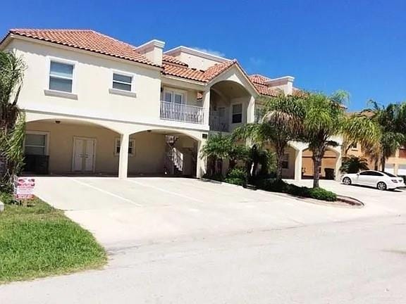 102 E Gardenia St Unit 8, South Padre Island, TX 78597 - mediterranean / spanish house with a tile roof, stucco siding, a carport, and driveway