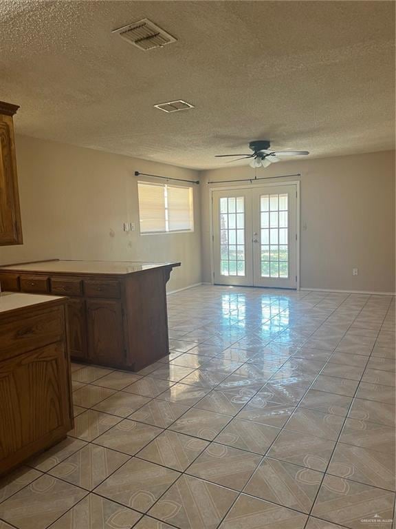 kitchen with ceiling fan, a textured ceiling, and french doors