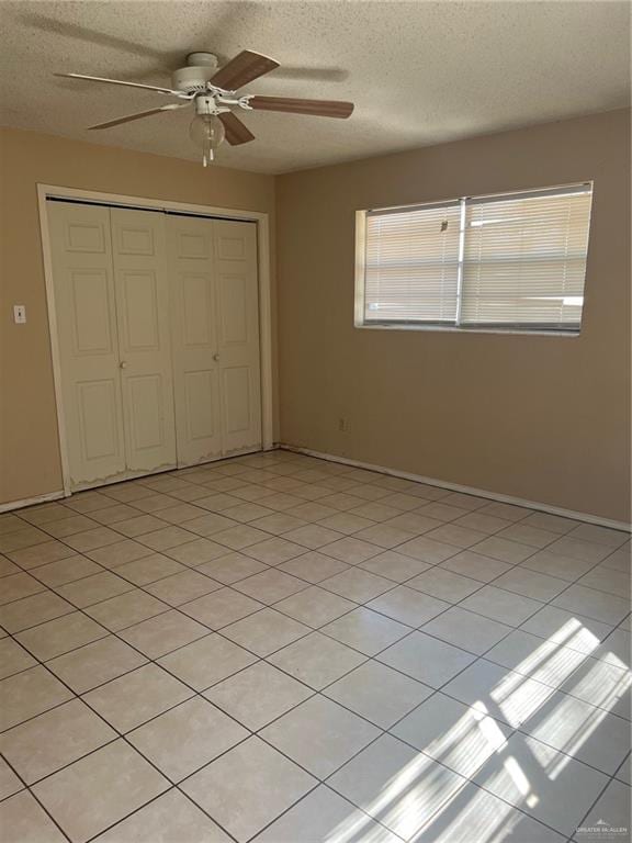 unfurnished bedroom with ceiling fan, a closet, and a textured ceiling