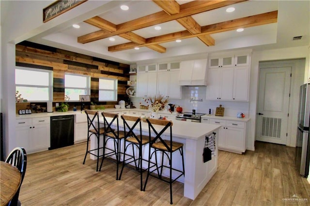 kitchen featuring premium range hood, a center island, and white cabinets