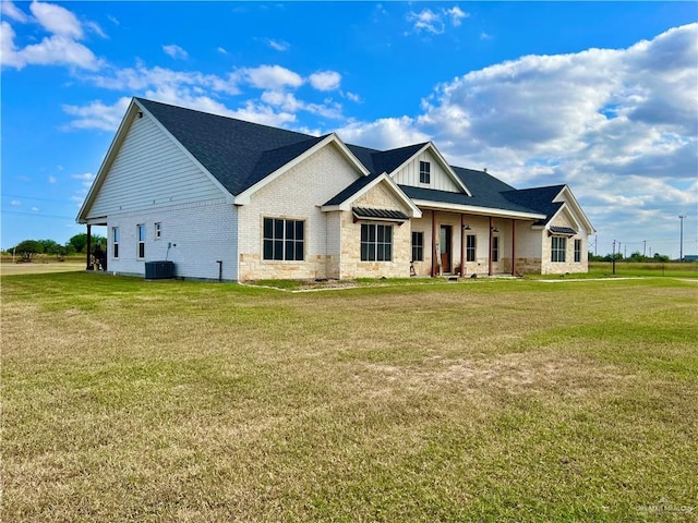 view of front of property with central AC and a front lawn